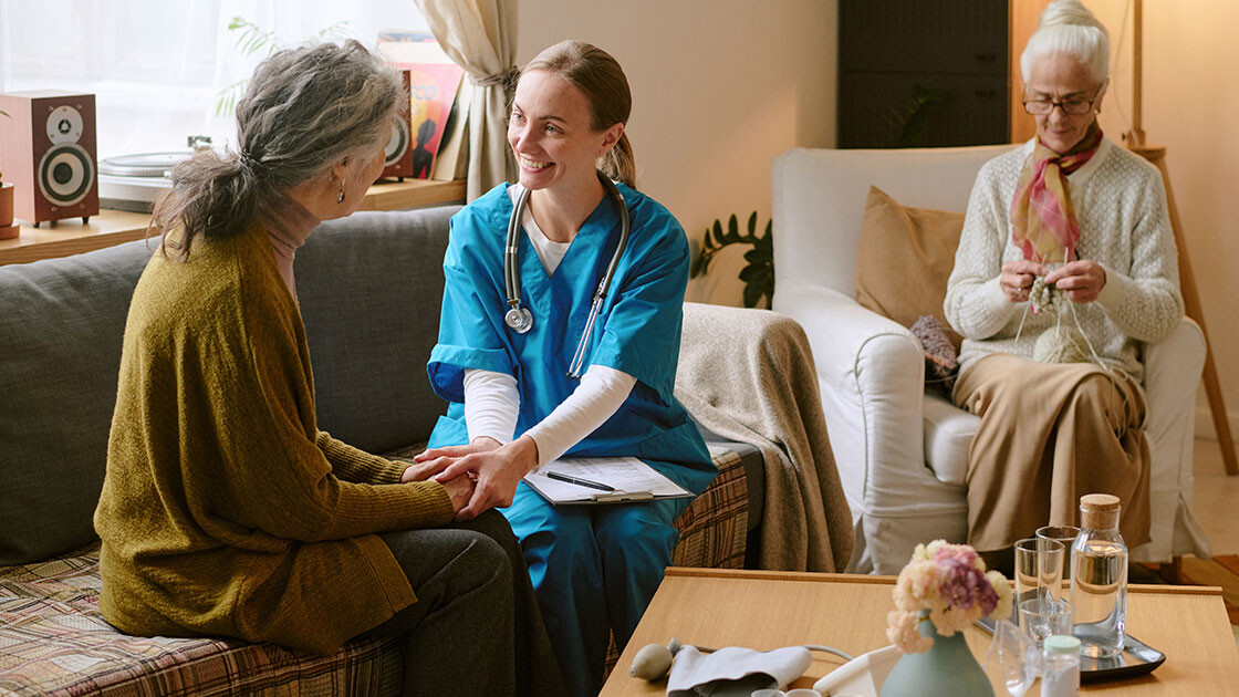 Nurse consulting with senior resident in a warm care home environment, representing Clarity LTC’s commitment to efficiency and compassionate technology.