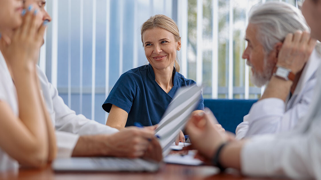 Nursing and administrative leaders collaborating during a healthcare finance meeting in a long-term care facility.