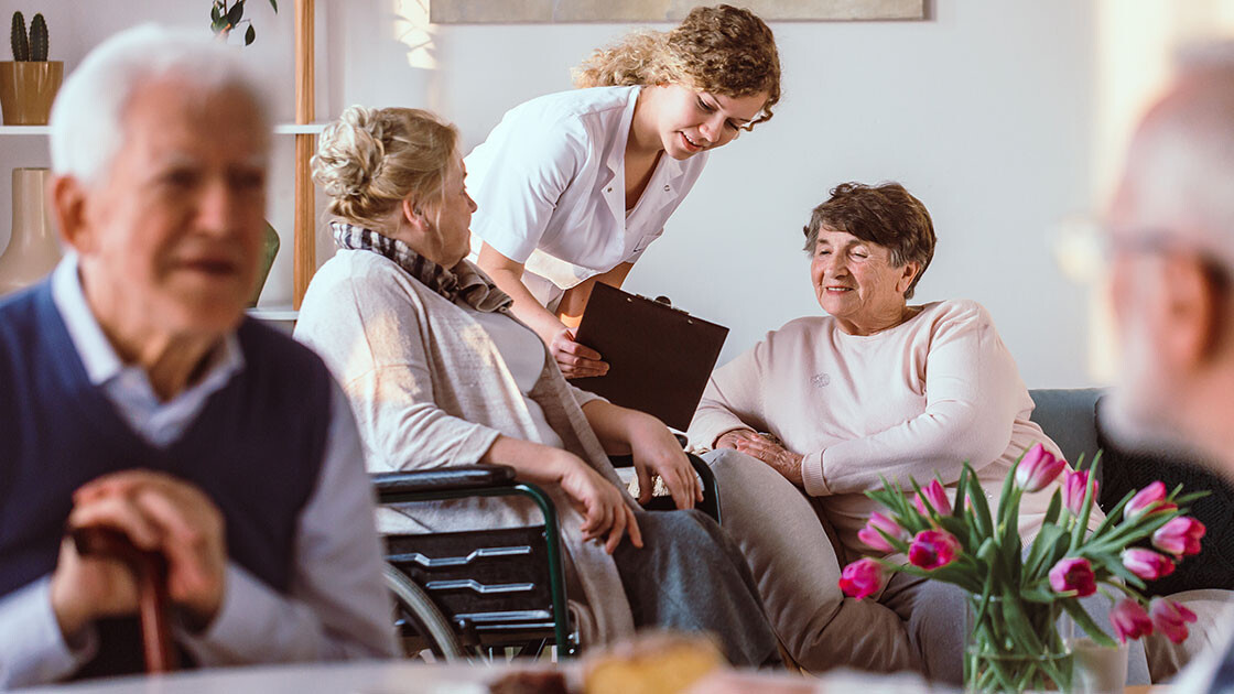 Nurse helping senior residents with medication at a long-term care facility, representing Clarity LTC’s focus on efficiency and transparent pricing.