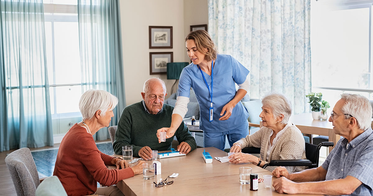 Caregiver speaking with senior residents in a nursing home environment, illustrating the value and transparency Clarity LTC brings to care facilities.