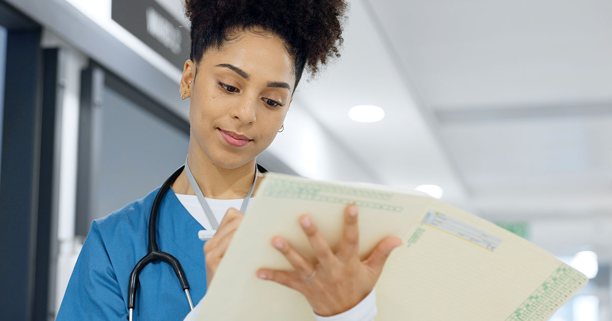 Long-term care nurse documenting patient care and reviewing records during daily clinical workflows